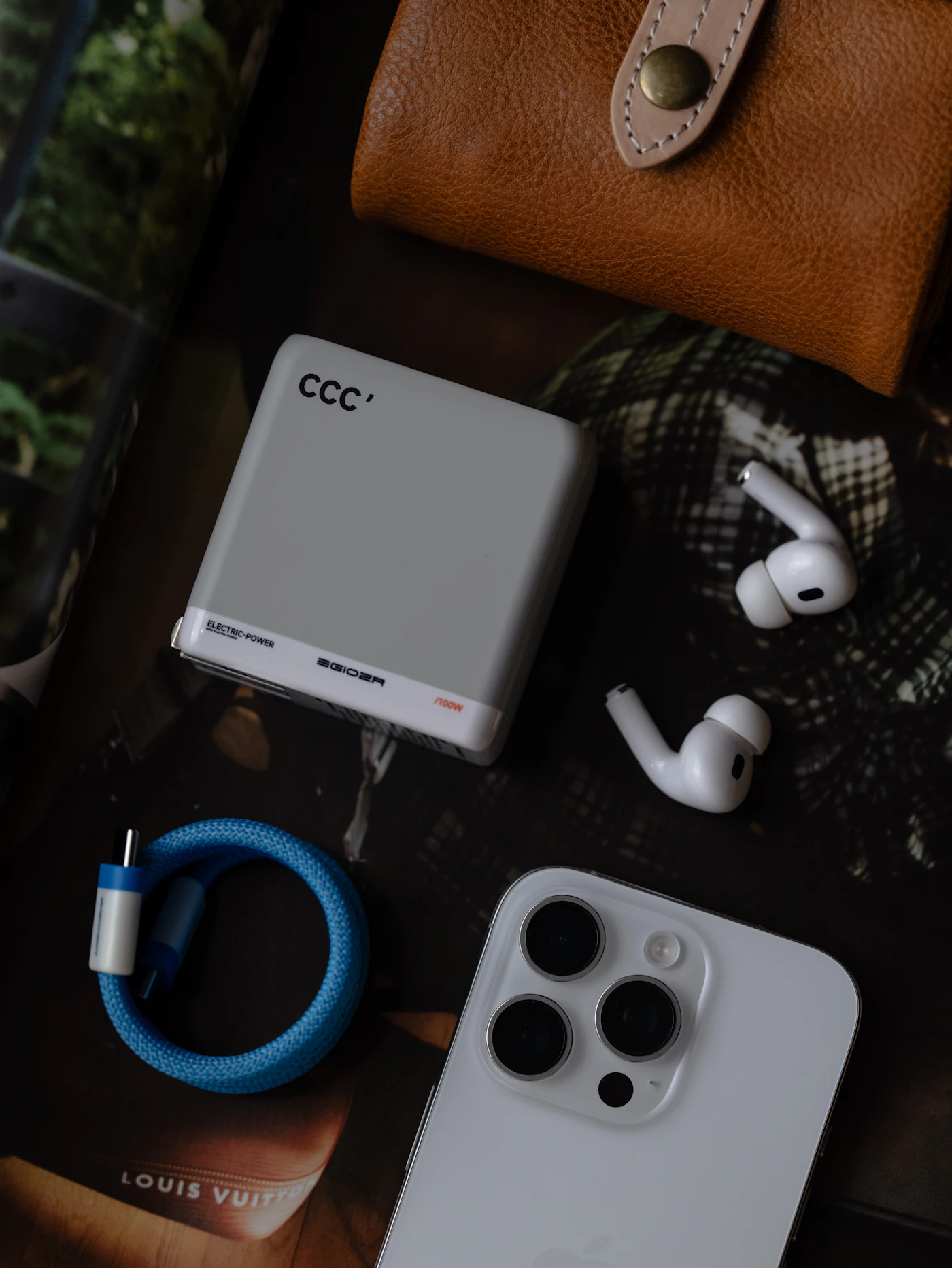 Smartphone, power bank, wireless earbuds, and wallet on surface